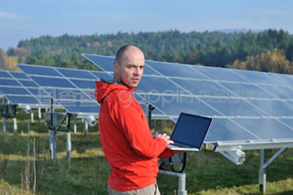 在太陽能電池板工廠使用筆記本電腦的工程師