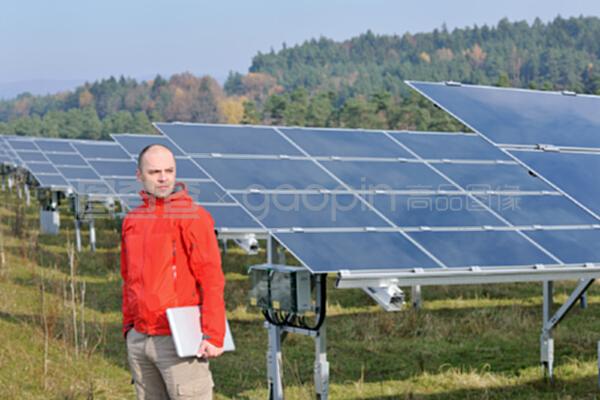 在太陽能電池板工廠使用筆記本電腦的工程師